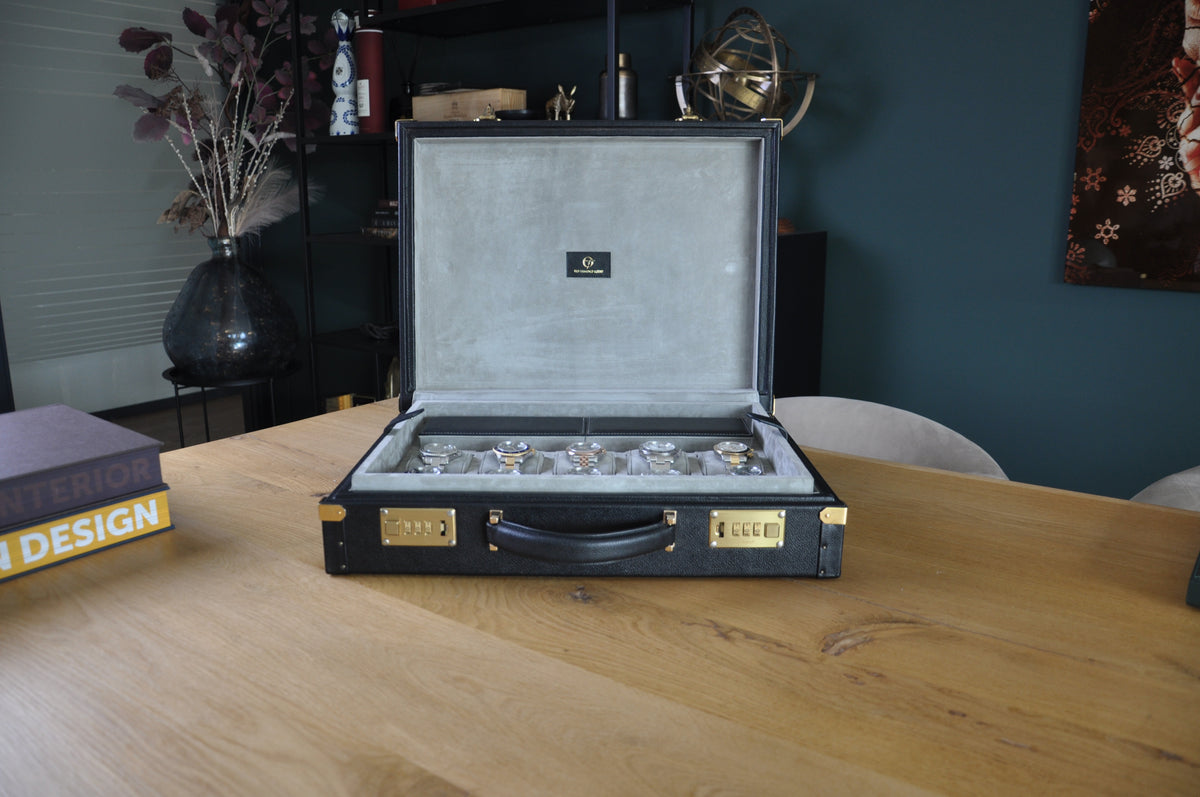 OFL black leather watch case, open, displayed on a wooden table