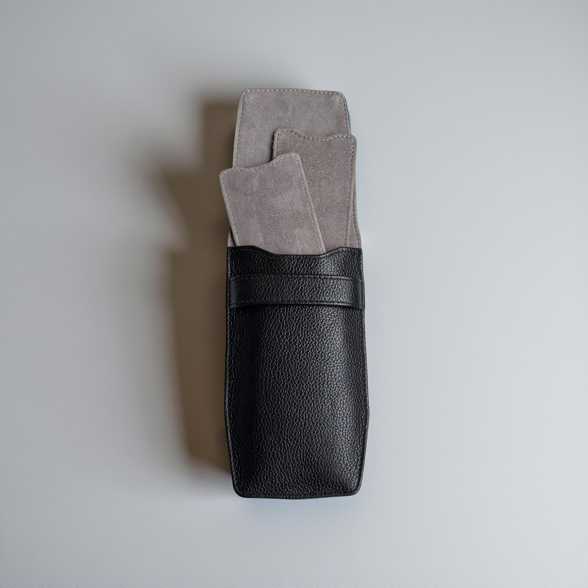 OFL handcrafted black full-grain leather watch pouch, open, showing the soft grey suede lining